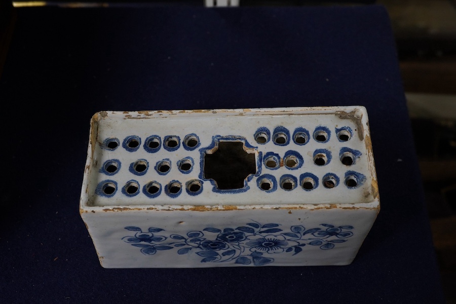 An 18th century English delftware flower brick, 15cm wide, 8cm high. Condition - edges chipped and larger chip to one corner, usual for pottery type, use and age